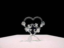 handblown glass Angels wedding cake top with 2 solid glass Angels inside a heart with flowers and leaves on a three leaves base.