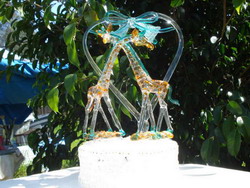 Giraffe wedding cake top with two solid glass giraffes, wedding heart, wedding bells, wedding bow on a glass case
