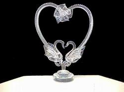 custom hand blown glass swans wedding cake top with a heart and flowers in the background