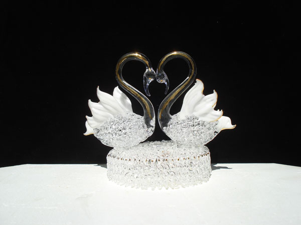 Swan wedding cake top with two swans making a heart.